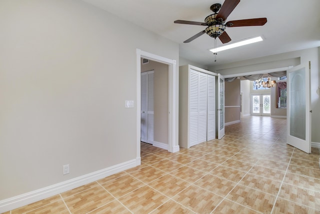 unfurnished room featuring french doors, light tile patterned flooring, ceiling fan, and baseboards