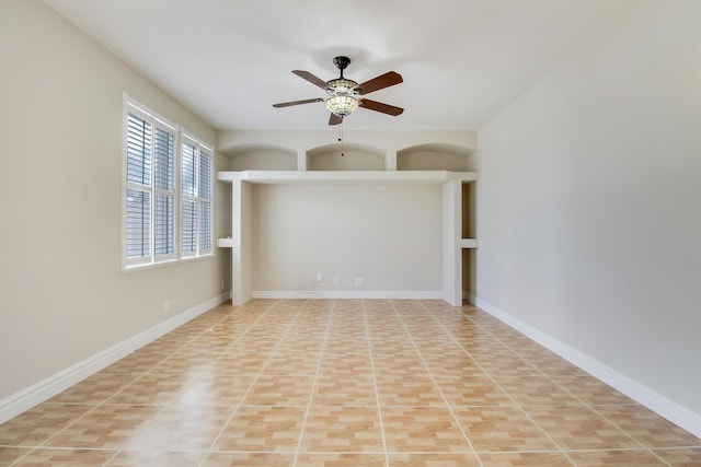 spare room featuring ceiling fan and baseboards