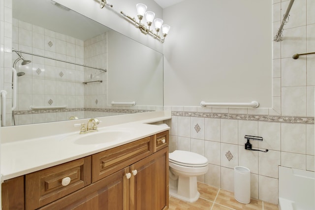 full bathroom with tile walls, toilet, wainscoting, vanity, and tile patterned flooring