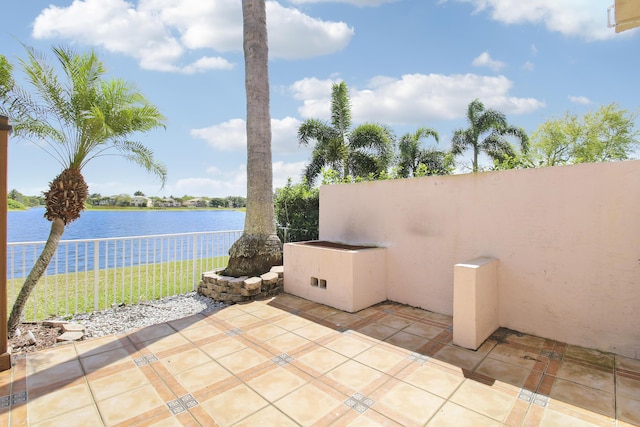 view of patio / terrace featuring a water view and fence