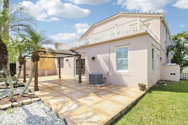 rear view of house with central AC unit, a balcony, stucco siding, a pergola, and a patio area