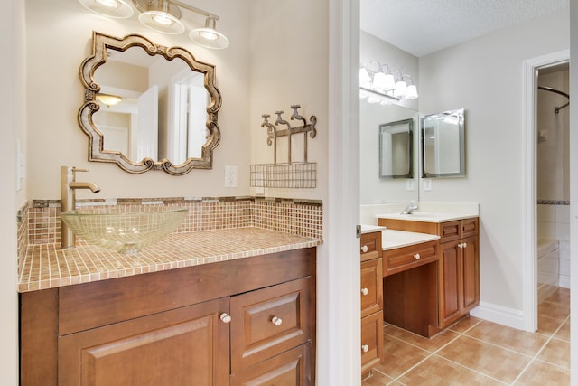 bathroom featuring tile patterned flooring, a textured ceiling, two vanities, and a sink