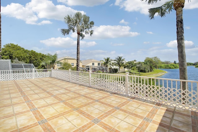 view of patio / terrace featuring a water view and fence