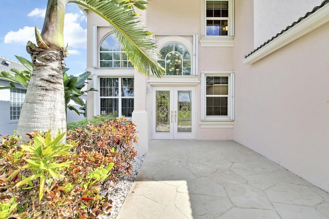 entrance to property featuring stucco siding and french doors