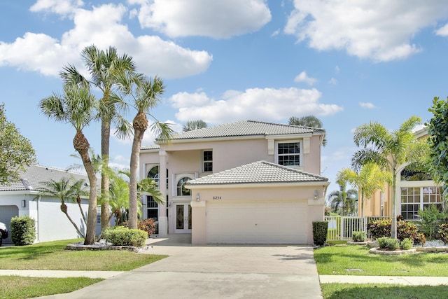 view of front of home with a garage, a tiled roof, concrete driveway, and stucco siding