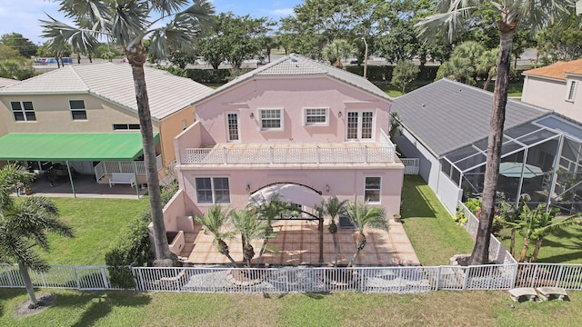 back of property with a fenced backyard, a tile roof, a yard, stucco siding, and a patio area