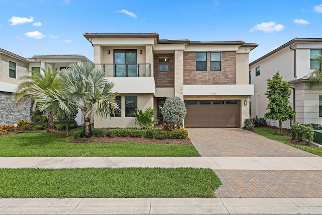 17072 Teton River Rd, Boca Raton, FL 33496 - view of front facade featuring decorative driveway, stucco siding, an attached garage, a balcony, and stone siding