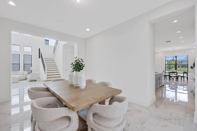 dining space with marble finish floor, recessed lighting, an inviting chandelier, baseboards, and stairs