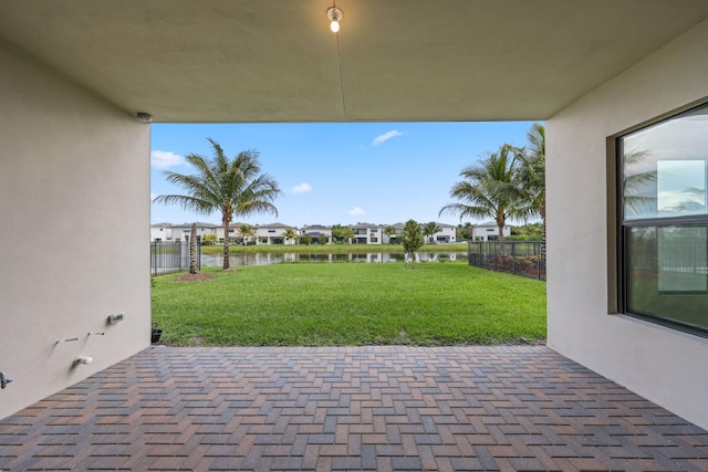 view of patio featuring a water view, a residential view, and fence