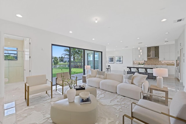 living area with marble finish floor, visible vents, and recessed lighting