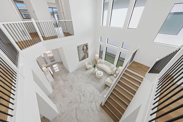 living area with marble finish floor and a high ceiling