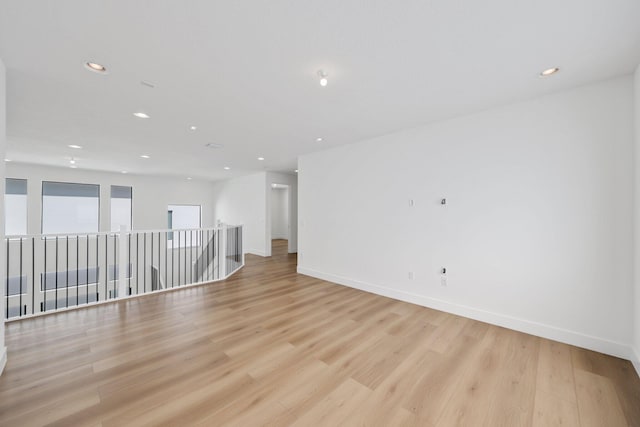 empty room featuring baseboards, light wood-style flooring, and recessed lighting