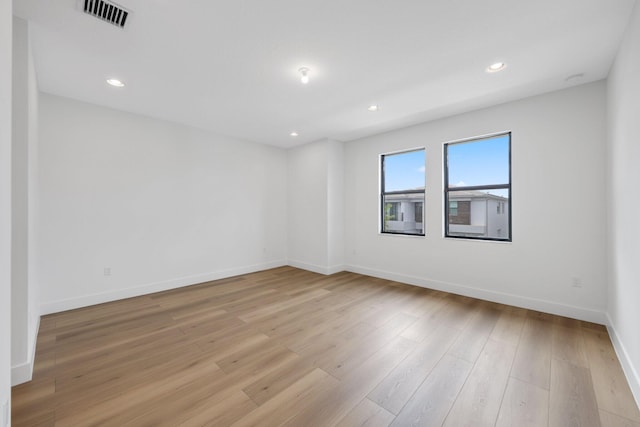 empty room featuring light wood-style flooring, recessed lighting, visible vents, and baseboards