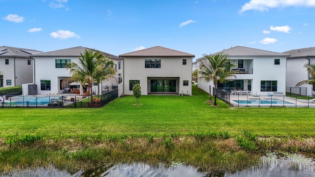 rear view of house featuring a patio, a balcony, a lawn, a fenced in pool, and stucco siding