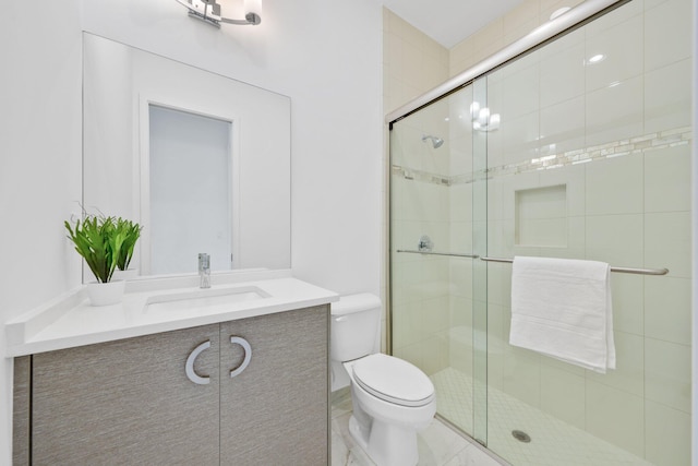 bathroom featuring a stall shower, vanity, and toilet