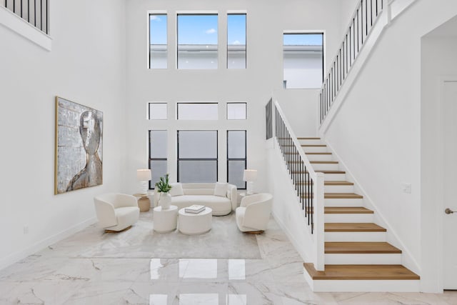 entrance foyer with marble finish floor, baseboards, and a wealth of natural light