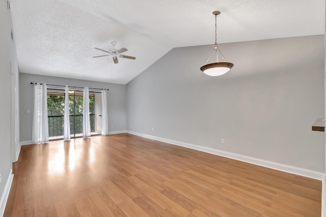 spare room with lofted ceiling, ceiling fan, a textured ceiling, baseboards, and light wood finished floors