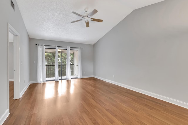 unfurnished room with light wood finished floors, lofted ceiling, a ceiling fan, a textured ceiling, and baseboards