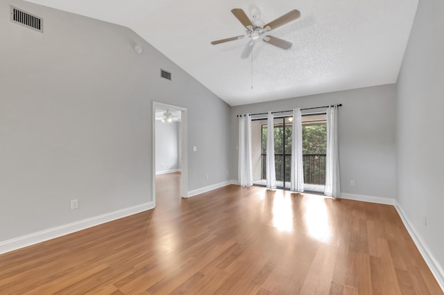 empty room featuring lofted ceiling, visible vents, ceiling fan, and light wood-style flooring