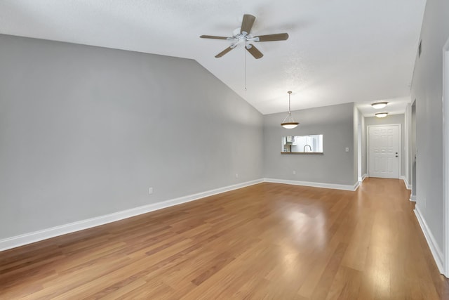 unfurnished room featuring baseboards, ceiling fan, vaulted ceiling, and light wood-style floors