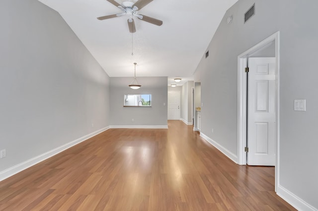 unfurnished room with a ceiling fan, visible vents, baseboards, and wood finished floors