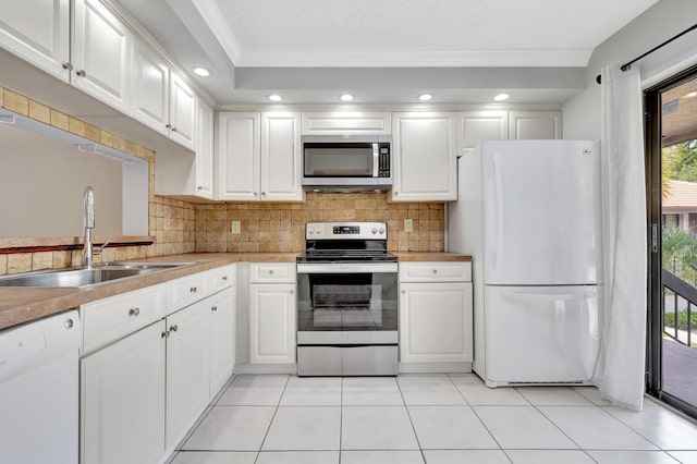 kitchen with tasteful backsplash, white cabinetry, stainless steel appliances, and a sink