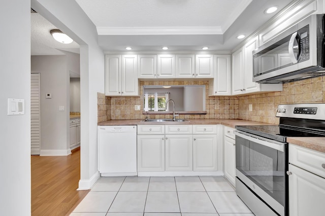 kitchen featuring stainless steel appliances, a sink, and white cabinetry