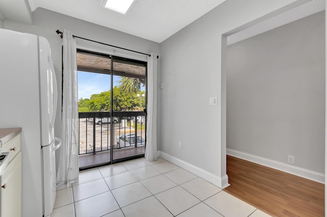 interior space with light tile patterned floors and baseboards