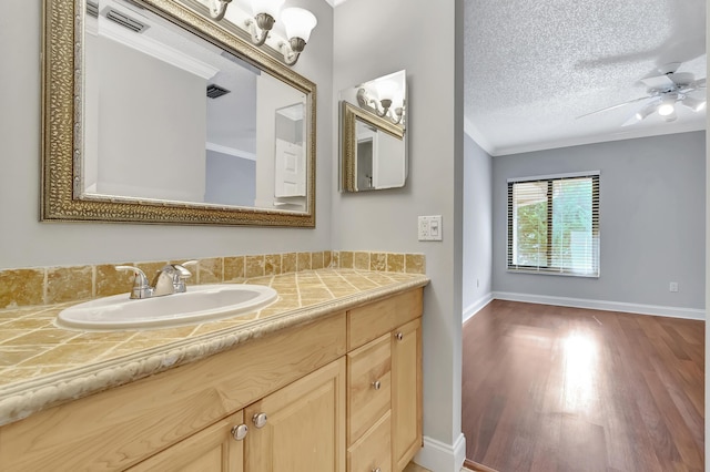 bathroom with crown molding, visible vents, a ceiling fan, a textured ceiling, and wood finished floors