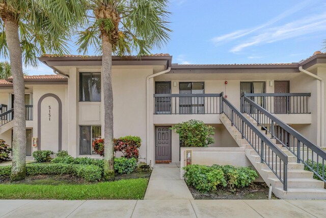 view of property featuring stairway and stucco siding