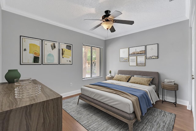 bedroom with crown molding, a textured ceiling, and wood finished floors