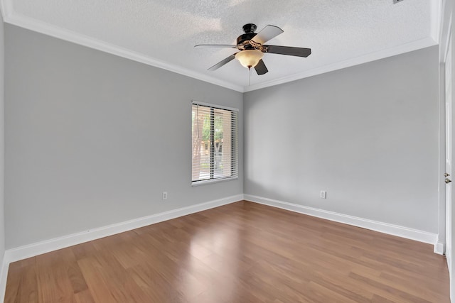 empty room with crown molding, baseboards, ceiling fan, and wood finished floors