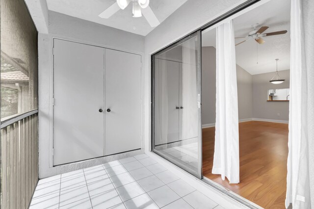 interior space with vaulted ceiling, a closet, a ceiling fan, and baseboards