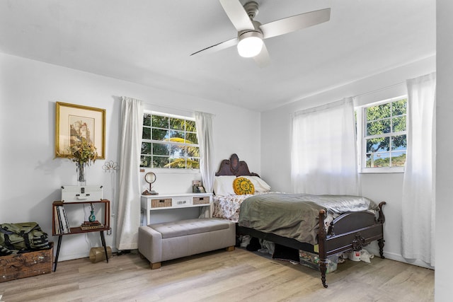 bedroom with multiple windows, ceiling fan, and wood finished floors