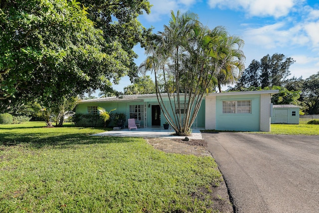 single story home with driveway and a front lawn