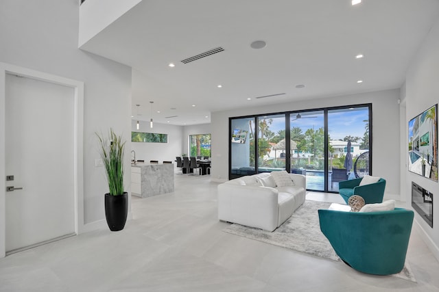 living area featuring recessed lighting, visible vents, and baseboards