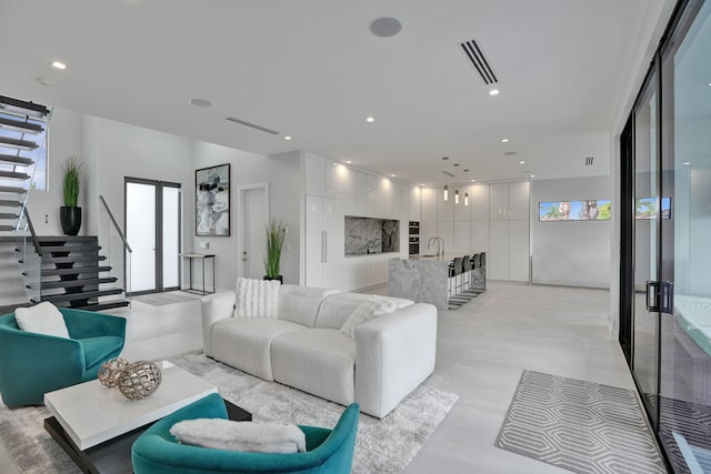 living area featuring stairway, visible vents, and recessed lighting