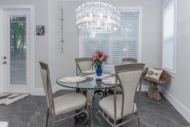 dining area with a notable chandelier, baseboards, and wood finished floors