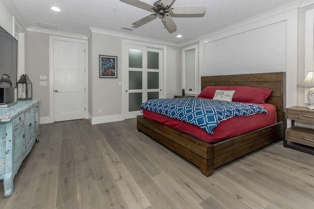 bedroom with light wood-type flooring, visible vents, crown molding, and recessed lighting