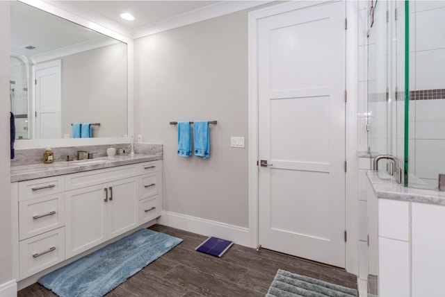 full bath featuring ornamental molding, a stall shower, vanity, wood finished floors, and baseboards