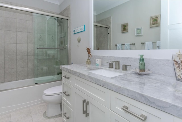 bathroom with bath / shower combo with glass door, vanity, toilet, and tile patterned floors