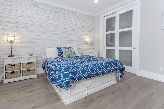 bedroom featuring crown molding, baseboards, wood finished floors, and recessed lighting