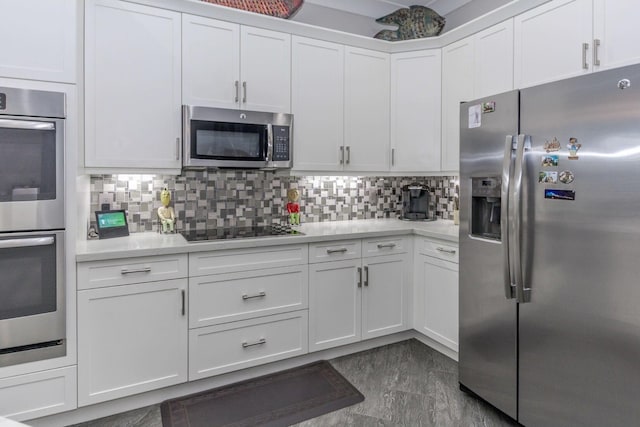 kitchen with stainless steel appliances, tasteful backsplash, light countertops, and white cabinetry