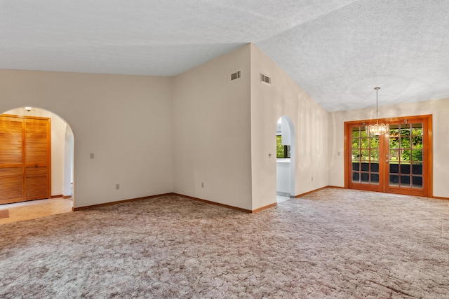 spare room with arched walkways, vaulted ceiling, carpet flooring, and visible vents