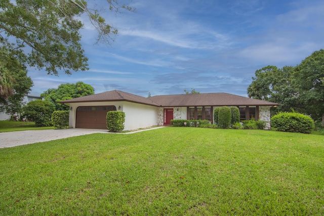 ranch-style home with a garage, driveway, a front lawn, and stucco siding