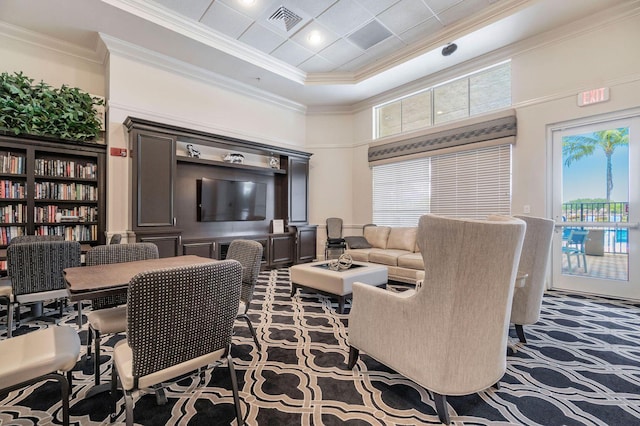 carpeted living area with ornamental molding, visible vents, and a high ceiling