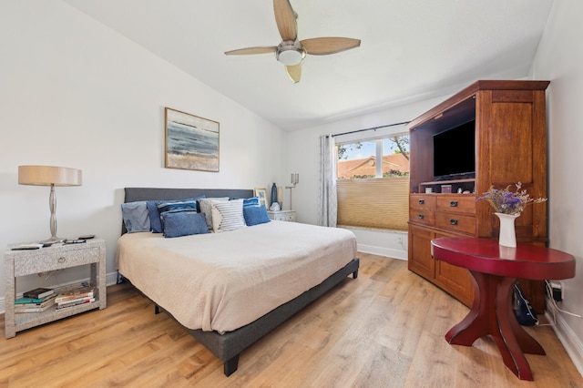 bedroom featuring vaulted ceiling, baseboards, a ceiling fan, and light wood-style floors