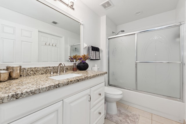 bathroom featuring toilet, shower / bath combination with glass door, vanity, visible vents, and tile patterned floors