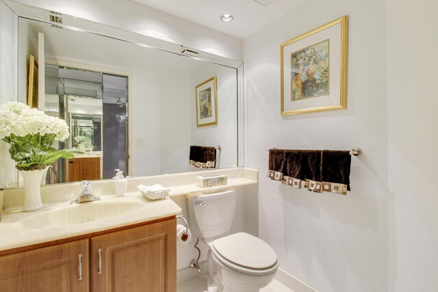 bathroom with toilet, recessed lighting, and vanity