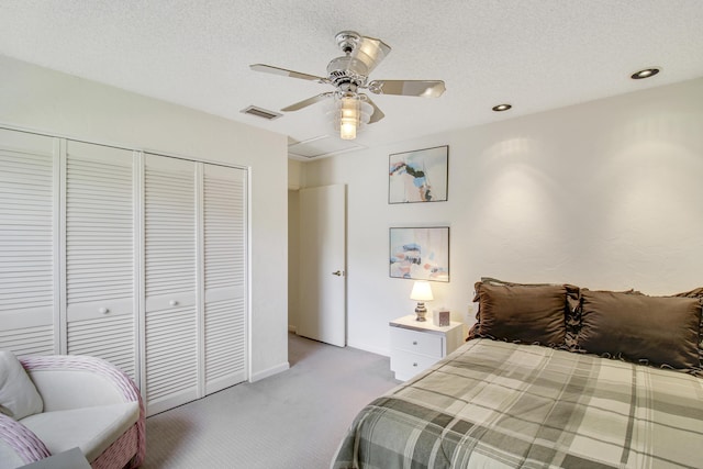 bedroom with a textured ceiling, a closet, carpet, and visible vents